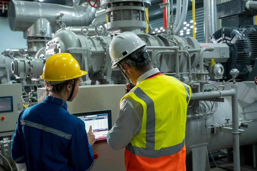 Two technical workers with tablet working in control room plant at industry factory,Business and industry concept.